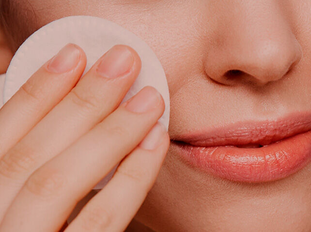 Imagen categoría limpieza facial con una mujer limpiándose la cara con un disco de algodón